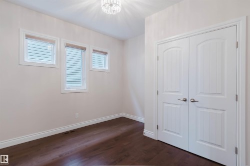 This room features rich dark wood flooring and a light-colored ceiling with a chandelier - 4875 Wright Drive, Edmonton, AB - Indoor Photo Showing Other Room