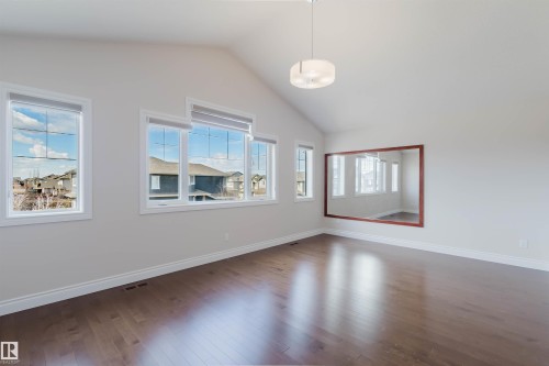 This room features a vaulted ceiling, hardwood floors, and abundant natural light from multiple windows - 4875 Wright Drive, Edmonton, AB - Indoor Photo Showing Other Room