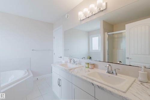 Bathroom with a corner bathtub, dual vanity with undermount sinks, and a shower with a sliding glass door - 4875 Wright Drive, Edmonton, AB - Indoor Photo Showing Bathroom