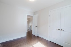 This room features rich hardwood floors, crisp white walls, and a convenient closet with white double doors - 