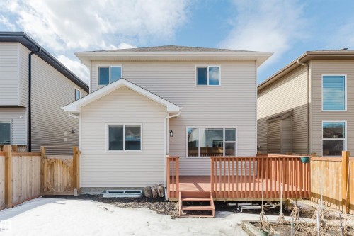 The property features a light-colored exterior siding and a spacious wooden deck with railings and steps - 4875 Wright Drive, Edmonton, AB - Outdoor With Exterior