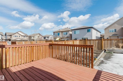 The property features a wooden deck with a matching wooden railing, overlooking a fenced backyard - 4875 Wright Drive, Edmonton, AB - Outdoor With Deck Patio Veranda With Exterior