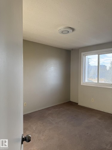 Room featuring neutral toned walls, brown carpeting, and a window providing natural light - 124 Cornell Court, Edmonton, AB - Indoor Photo Showing Other Room