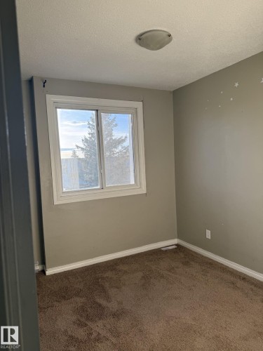 This room features neutral-toned walls, a window providing natural light, and brown carpeting - 124 Cornell Court, Edmonton, AB - Indoor Photo Showing Other Room
