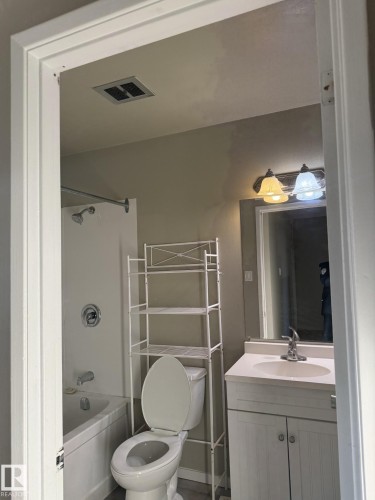 Bathroom featuring a white vanity with a countertop sink, a white toilet, and a white bathtub with a shower - 124 Cornell Court, Edmonton, AB - Indoor Photo Showing Bathroom