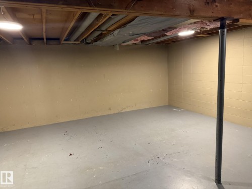 Spacious basement area featuring a concrete floor and exposed wood ceiling beams - 124 Cornell Court, Edmonton, AB - Indoor Photo Showing Basement