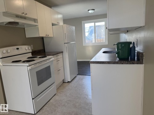 Well-appointed kitchen featuring white cabinetry, a white range, a white refrigerator, and a window providing natural light - 124 Cornell Court, Edmonton, AB - Indoor Photo Showing Kitchen