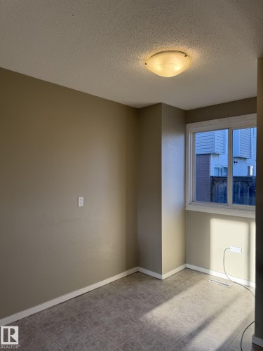 This room features tile flooring, neutral-toned walls, and a window providing natural light - 124 Cornell Court, Edmonton, AB - Indoor Photo Showing Other Room