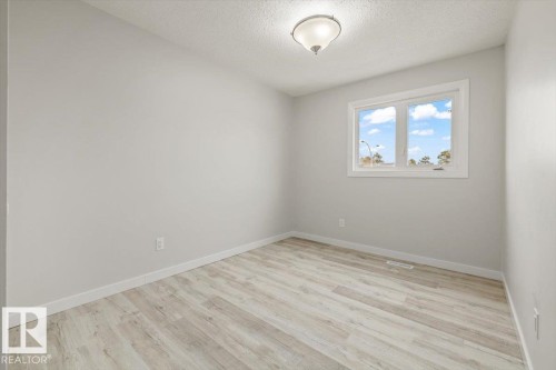 This room features light-colored walls and wood-look flooring, creating a bright and airy atmosphere - 12C Castle Terrace, Edmonton, AB - Indoor Photo Showing Other Room