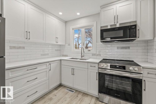 The kitchen features white shaker-style cabinetry, a white subway tile backsplash, and light-colored countertops - 12C Castle Terrace, Edmonton, AB - Indoor Photo Showing Kitchen With Upgraded Kitchen