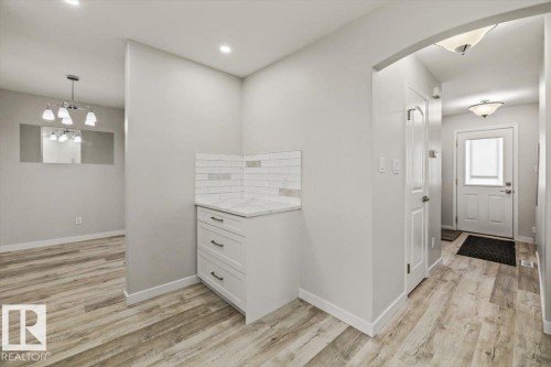 Entryway featuring light-toned flooring, a storage cabinet with a white countertop and tile backsplash, and an arched doorway - 12C Castle Terrace, Edmonton, AB - Indoor Photo Showing Other Room