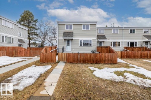 The property features a private fenced yard, a light-colored siding exterior, and multiple windows - 12C Castle Terrace, Edmonton, AB - Outdoor