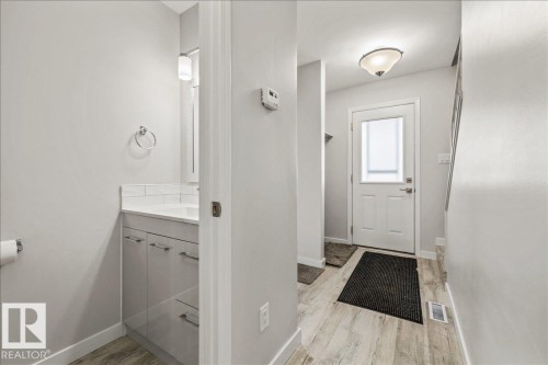 Entryway featuring light-toned flooring, a white door with a frosted glass panel, and a ceiling-mounted light fixture - 12C Castle Terrace, Edmonton, AB - Indoor