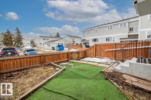 The property features a fenced yard with a combination of artificial turf and an earthy section - 12C Castle Terrace, Edmonton, AB - Outdoor
