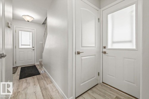 Entryway featuring light-toned flooring, white walls, and a staircase with light-colored carpeting - 12C Castle Terrace, Edmonton, AB - Indoor Photo Showing Other Room