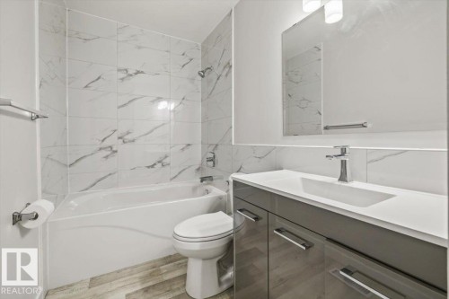 The bathroom features a modern vanity with a white countertop and a rectangular sink, complemented by a large mirror and overhead lighting - 12C Castle Terrace, Edmonton, AB - Indoor Photo Showing Bathroom