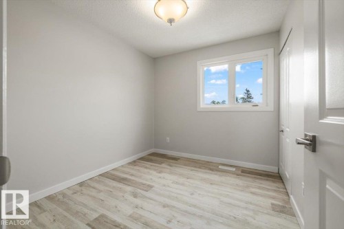 This room features light-colored walls, wood-style flooring, and a window providing natural light - 12C Castle Terrace, Edmonton, AB - Indoor Photo Showing Other Room