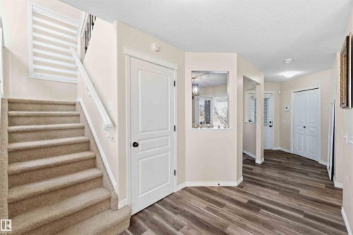 The entryway features wood-look flooring and a carpeted staircase with a white railing - 31 Everitt Drive, St. Albert, AB - Indoor Photo Showing Other Room