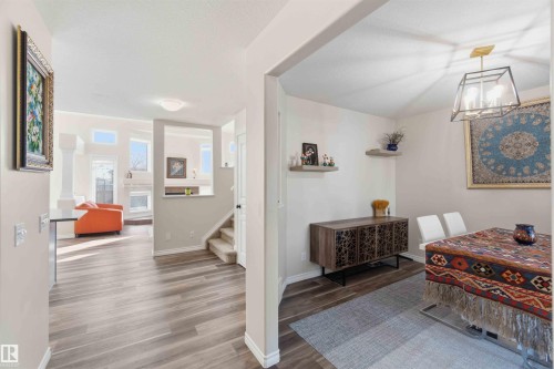 The property features light-toned flooring throughout, with a dining area illuminated by a modern light fixture - 31 Everitt Drive, St. Albert, AB - Indoor Photo Showing Other Room