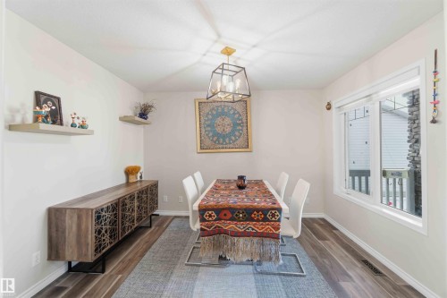 Dining area featuring light-colored walls, wood-style flooring, and a large window providing natural light - 31 Everitt Drive, St. Albert, AB - Indoor Photo Showing Dining Room