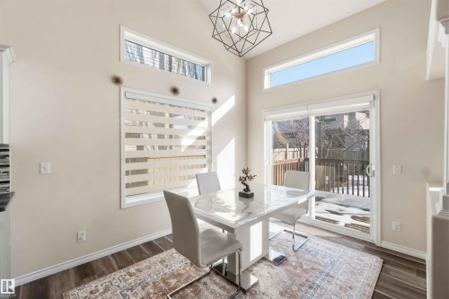 The dining area features high ceilings, a sliding glass door leading to an outdoor space, and large windows providing ample natural light - 31 Everitt Drive, St. Albert, AB - Indoor