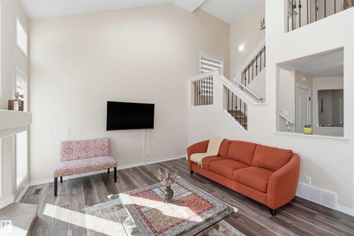 Living area featuring vaulted ceilings, large windows, and dark wood-style flooring - 31 Everitt Drive, St. Albert, AB - Indoor Photo Showing Living Room