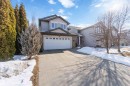 The property features a two-story exterior with light gray siding, a white garage door, and a concrete driveway - 31 Everitt Drive, St. Albert, AB  - Outdoor With Facade 