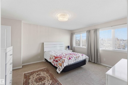 This room features two windows with horizontal blinds, neutral-toned walls, and carpeted flooring - 31 Everitt Drive, St. Albert, AB - Indoor Photo Showing Bedroom