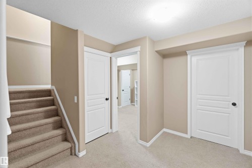 Interior space featuring neutral-toned walls, light-colored carpet, white doors with black hardware, and white trim - 31 Everitt Drive, St. Albert, AB - Indoor Photo Showing Other Room