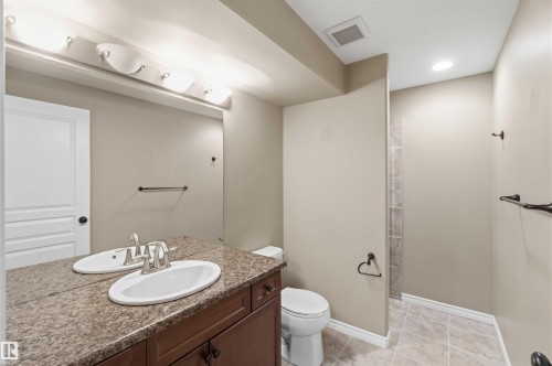 Bathroom featuring a vanity with a granite countertop, two undermount sinks, and a toilet - 31 Everitt Drive, St. Albert, AB - Indoor Photo Showing Bathroom