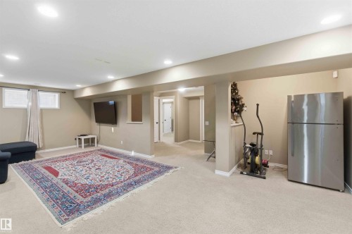 The property features a spacious room with light-colored carpeting, recessed lighting, and a window providing natural light - 31 Everitt Drive, St. Albert, AB - Indoor Photo Showing Basement