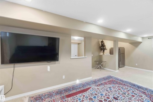This inviting room features recessed lighting, light-colored carpeting, and a refrigerator, offering a versatile space - 31 Everitt Drive, St. Albert, AB - Indoor Photo Showing Other Room