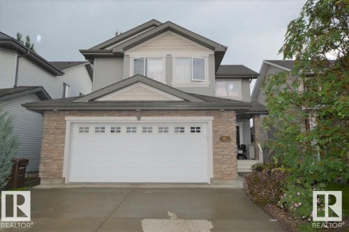 The property features a two-story exterior with light gray siding and stone accents on the lower level - 31 Everitt Drive, St. Albert, AB - Outdoor