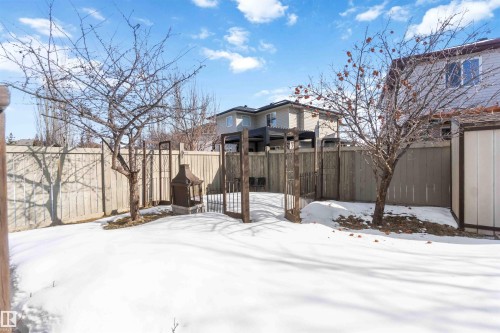 The property features a fenced yard with mature trees and a gate - 31 Everitt Drive, St. Albert, AB - Outdoor