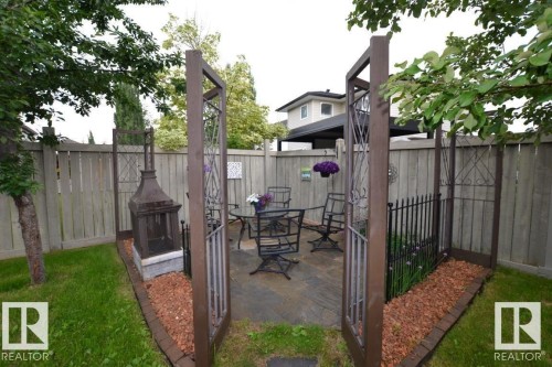The property features a fenced yard with a paved patio, a built-in outdoor fireplace, and a lawn area - 31 Everitt Drive, St. Albert, AB - Outdoor