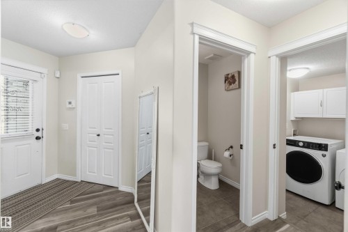 The entrance area features wood-look flooring, a white door with a window and blinds, and a white bi-fold closet - 31 Everitt Drive, St. Albert, AB - Indoor Photo Showing Laundry Room