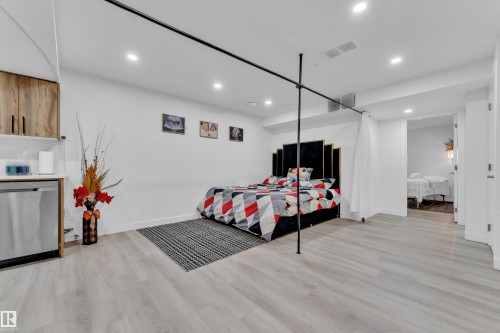 This versatile space features light-toned flooring, recessed lighting, and a compact kitchenette with wooden cabinetry and a stainless steel appliance - 1645 Plum Circle, Edmonton, AB - Indoor Photo Showing Other Room