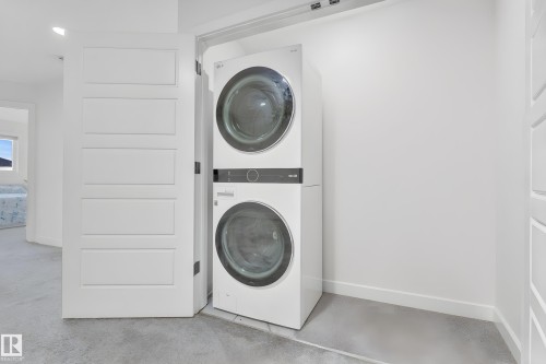 Dedicated laundry area featuring a stacked washer and dryer unit - 1645 Plum Circle, Edmonton, AB - Indoor Photo Showing Laundry Room