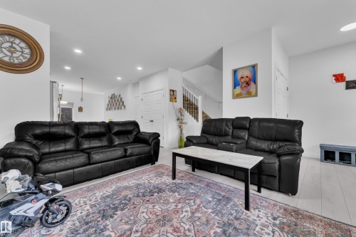 The living area features light-colored flooring, recessed lighting, and a neutral color palette - 1645 Plum Circle, Edmonton, AB - Indoor Photo Showing Living Room