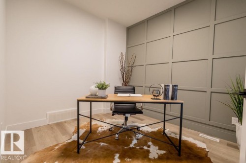 This room features light-colored flooring and a statement wall with decorative paneling - 102 Bluff Cove, Leduc, AB - Indoor Photo Showing Office