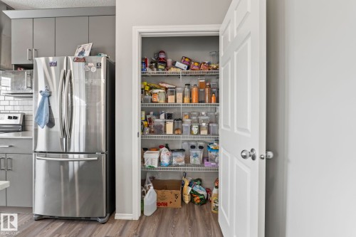 Kitchen featuring a full-size stainless steel refrigerator, grey cabinetry, and white subway tile backsplash - 5164 Lark Crescent Nw, Edmonton, AB - Indoor