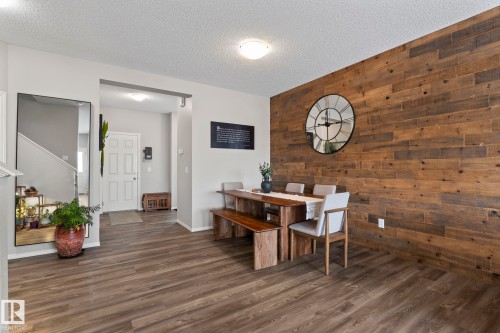 Dining area featuring wood plank flooring and a prominent wood accent wall - 5164 Lark Crescent Nw, Edmonton, AB - Indoor Photo Showing Dining Room