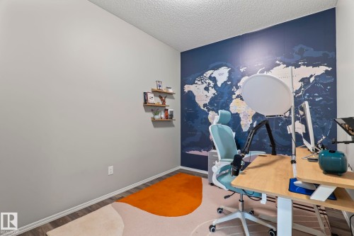 This room features light grey walls and an accent wall with a world map design - 5164 Lark Crescent Nw, Edmonton, AB - Indoor Photo Showing Office
