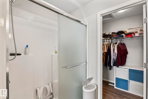 The bathroom features a shower with a sliding frosted glass door - 5164 Lark Crescent Nw, Edmonton, AB - Indoor With Storage