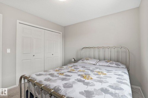 Bedroom featuring light grey walls, carpeted flooring, and a closet with bi-fold doors - 5164 Lark Crescent Nw, Edmonton, AB - Indoor Photo Showing Bedroom
