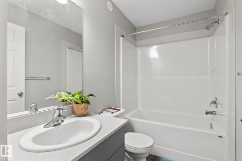 The bathroom features a vanity with an integrated sink and a large mirror - 5164 Lark Crescent Nw, Edmonton, AB - Indoor Photo Showing Bathroom