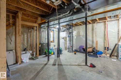 The unfinished basement features exposed wooden ceiling joists, concrete flooring, and metal support beams - 5164 Lark Crescent Nw, Edmonton, AB - Indoor Photo Showing Basement