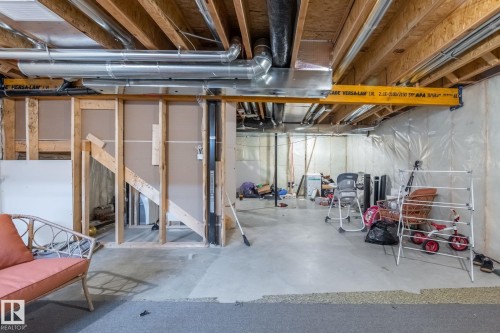 The property features an unfinished basement with exposed wooden joists and ductwork, providing an opportunity for customization - 5164 Lark Crescent Nw, Edmonton, AB - Indoor Photo Showing Basement