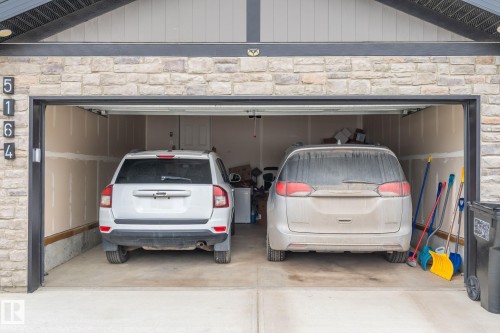 The property features a two-car garage with a concrete floor, offering practical space - 5164 Lark Crescent Nw, Edmonton, AB - Indoor Photo Showing Garage