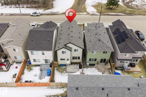 Aerial view of the property, showcasing its light-colored exterior, dark roof, and a fenced backyard - 5164 Lark Crescent Nw, Edmonton, AB - Outdoor